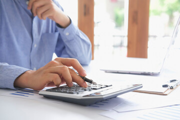 asian businessman or accountant working pointing graph discussion and analysis data charts and...