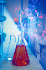 Glass laboratory flasks with chemical substance and magic glow. Making a magical love potion for...