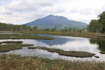 尾瀬/6月。　まだ水芭蕉が咲き残る初夏の尾瀬ヶ原。山、空が写る池。逆さ燧（ひうち）