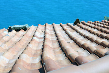Tetto rustico con tegole rosse e mare