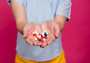Beautiful young woman holding many pills in her hands