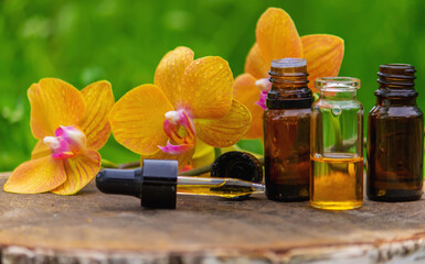 Massage oil and stones with yellow orchid. Natural oils.