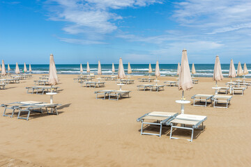 beach scene on the Adriatic sea in Italy with umbrellas and sun loungers 