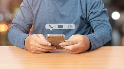 Young man using smartphone with icon phone, mail, and address. contact us.