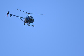 Helicopter flying under a blue sky