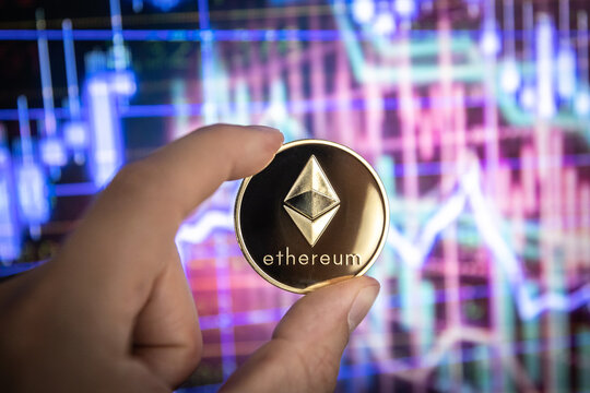 Ethereum cryptocurrency, physical coin in front of colorful charts and graphs