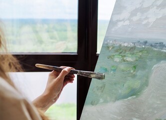 Woman Artist painting abstract oil painting in art studio. Close up photo paint brush in hand on...