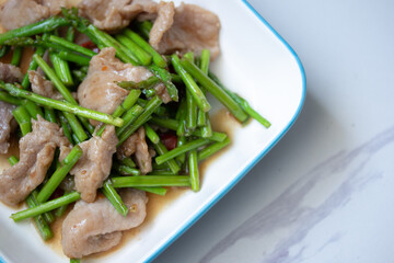 Asparagus sauteed with pork in a white ceramic dish