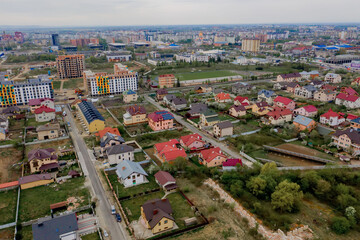 Aerial top view of a house with paved yard with green grass lawn with concrete foundation floor
