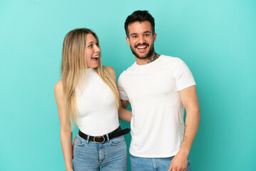 Young couple over isolated blue background with surprise facial expression