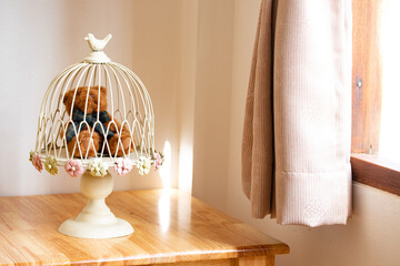 Teddy bear is on a wooden table inside the coffee shop.