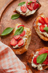 Strawberry toast brioche with cream cheese decorated with flowers and basil fflat lay close up