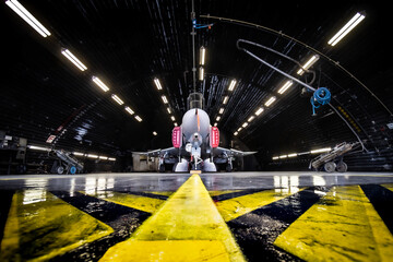Air force fighter jet aircraft inside a hangar at a military air base. - obrazy, fototapety, plakaty