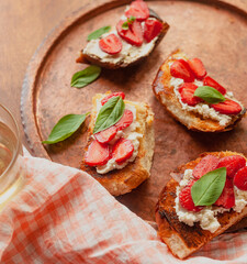 Strawberry toast brioche with cream cheese decorated with flowers and basil fflat lay close up
