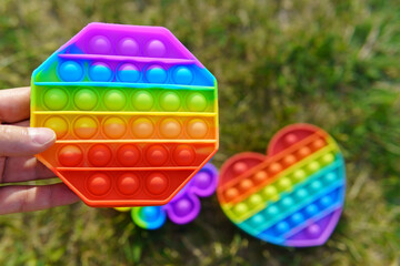 Colorful toy pop it in the form of a diamond in the hand close-up
