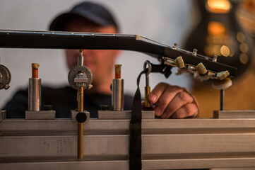 Fototapeta premium Guitar in repair service shop with a hands of a guitar luthier