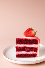 slice of red velvet cake with fresh strawberries. delicious layered dessert. pink background. vertical image