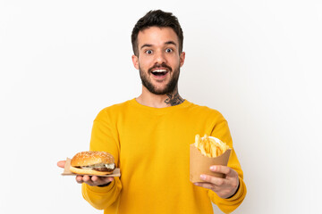 holding fried chips and cheeseburger over isolated background