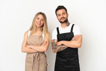 Restaurant waiter over isolated white background keeping the arms crossed in frontal position