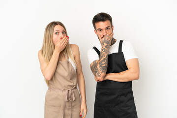 Restaurant waiter over isolated white background covering mouth with hands for saying something inappropriate
