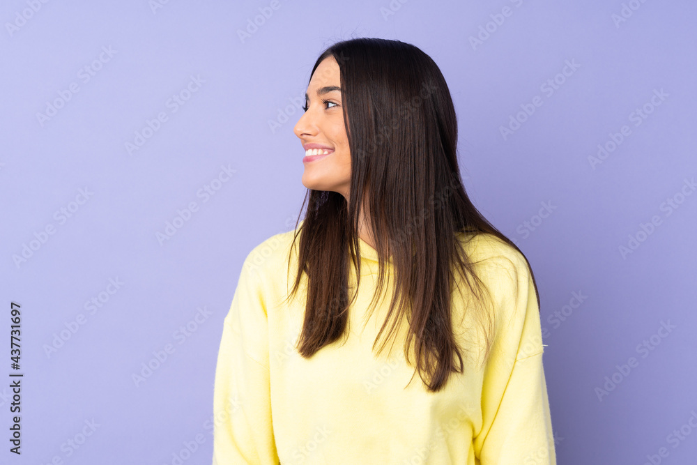 Wall mural young caucasian woman over isolated background looking side