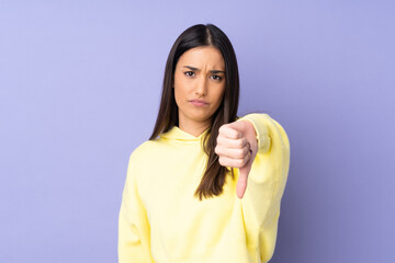 Young caucasian woman over isolated background showing thumb down with negative expression