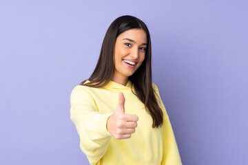 Young caucasian woman over isolated background with thumbs up because something good has happened
