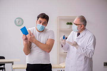 Young male patient visiting old male doctor in vaccination conce