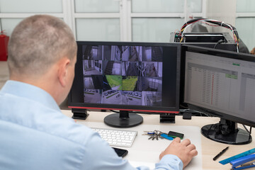 CCTV security system operator monitoring video cameras in security room. Surveillance, modern technology concept. selective focus