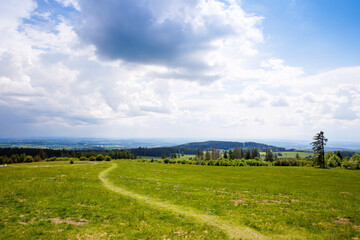 Fototapeta na wymiar Landscape on Hoherodskopf, volcano region in Hesse, Germany. On cloudy sunny warm summer day, meadows, hills, fields and forests.