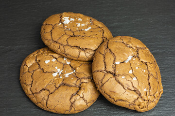 heap of chewy gluten-free chocolate cookies with flakes of sea salt
