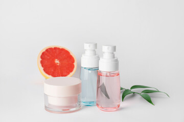 Natural cosmetic products with citrus fruit on grey background