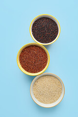 Bowls with healthy quinoa on color background
