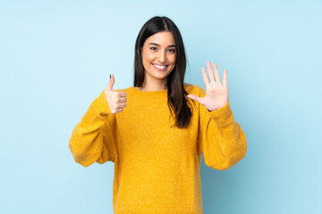 Young caucasian woman isolated on blue background counting six with fingers