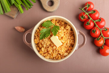 Pot of tasty cooked lentils on color background