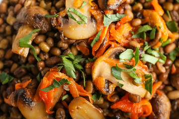 Heap of tasty cooked lentils with mushrooms, closeup