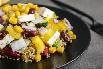 Plate with healthy quinoa salad on grunge background, closeup