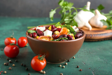 Bowl with healthy quinoa salad on color background