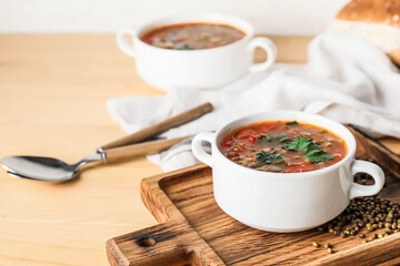 Pot of tasty lentil soup on table
