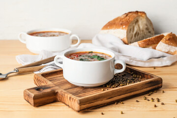 Pot of tasty lentil soup on table