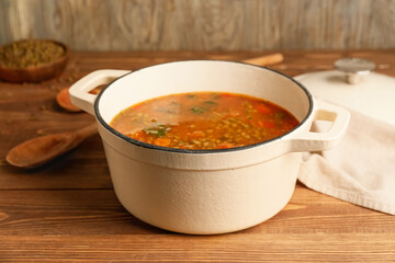 Pot of tasty lentil soup on table