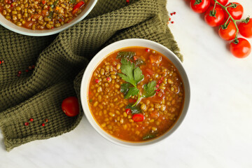 Bowl of tasty lentil soup on white background