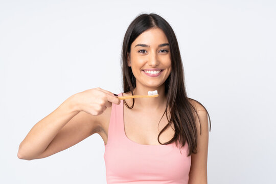 Young caucasian woman isolated on white background with a toothbrush and happy expression