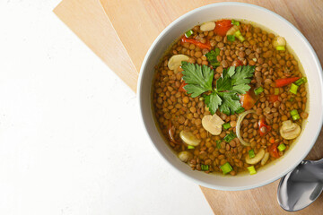 Bowl of tasty lentil soup on white background