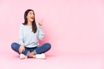 Young caucasian woman isolated on pink background intending to realizes the solution while lifting...