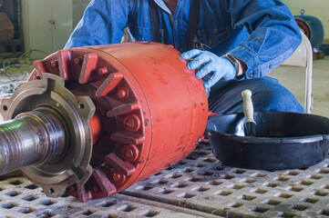 A man working on a 480 volts motor rotor, maintenance as part of apprentice technician program in...
