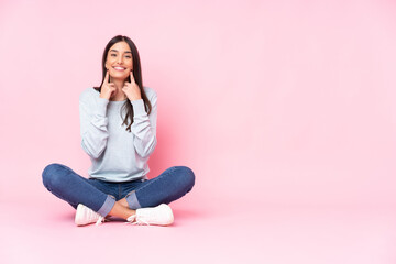 Young caucasian woman isolated on pink background smiling with a happy and pleasant expression