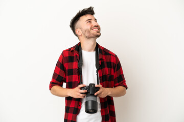 Young photographer caucasian man isolated on white background looking up while smiling