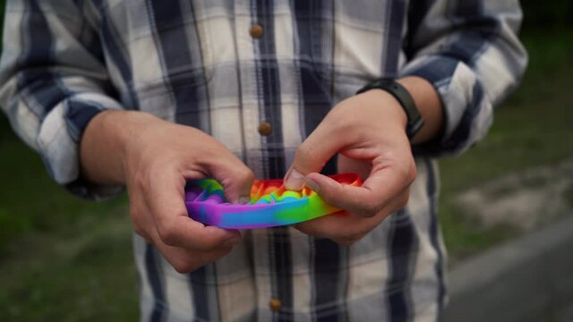 a man holding a pop it simple dimple toy popular in 2021