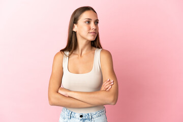 Fototapeta premium Young woman over isolated pink background looking to the side